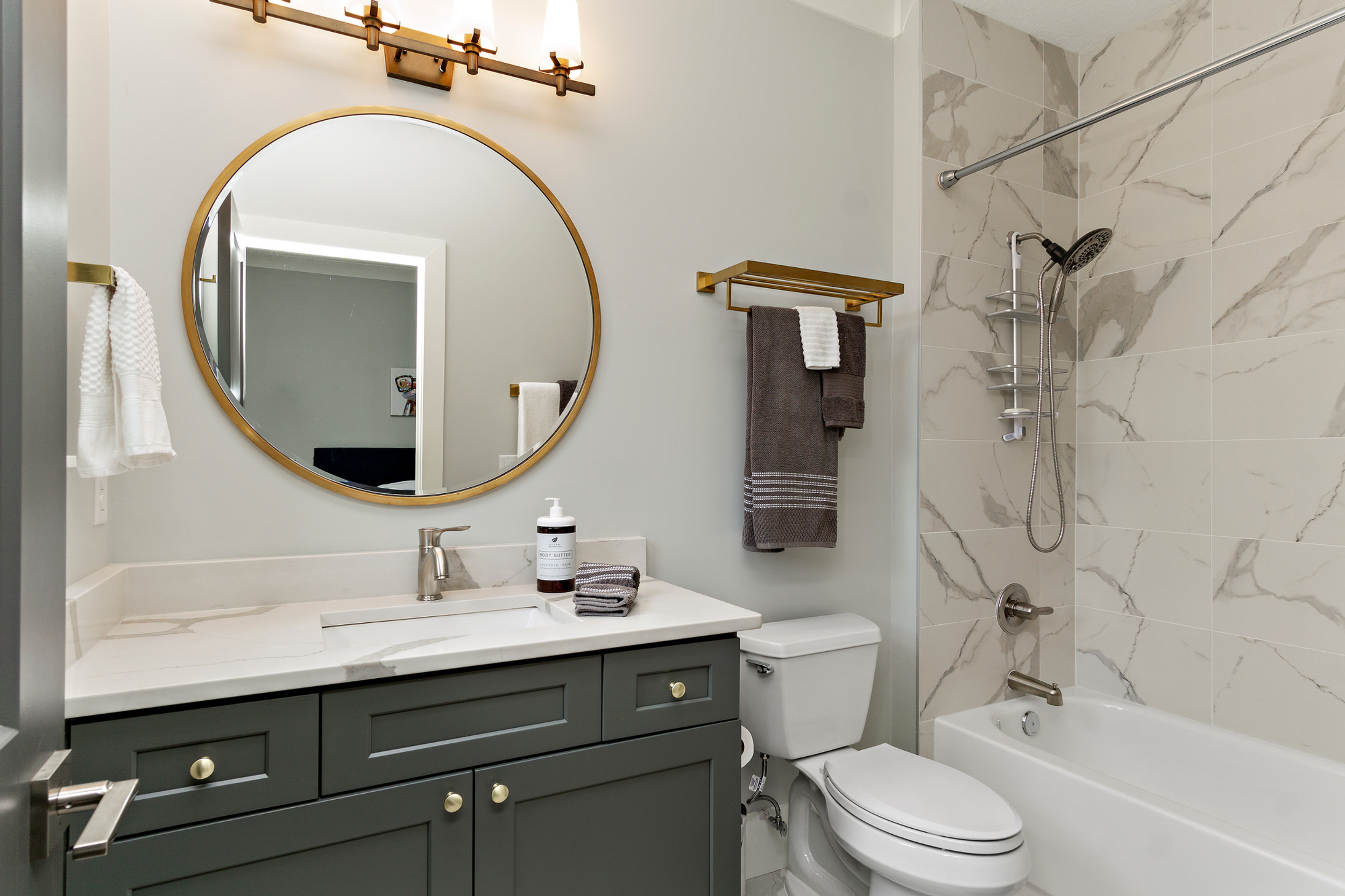 a bathroom remodeling with a sink, toilet, mirror and bathtub