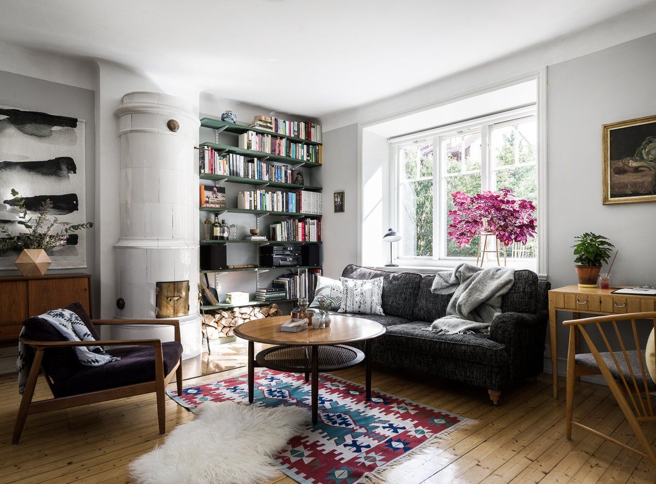 A well-furnished home organization living room showcasing a comfortable couch, a chair, a bookshelf, and a stylish rug