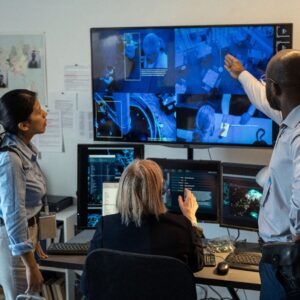 Team reviewing live CCTV feeds on large screens in a control room, highlighting advanced monitoring capabilities.